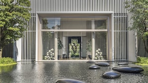 A modern building with a water feature in front. - Four Seasons Hotel Bangkok at Chao Phraya River (Bangkok)