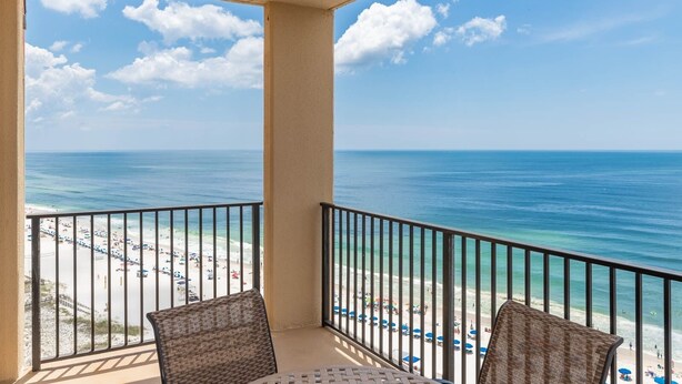 Ein Balkon mit Blick auf Strand und Meer.