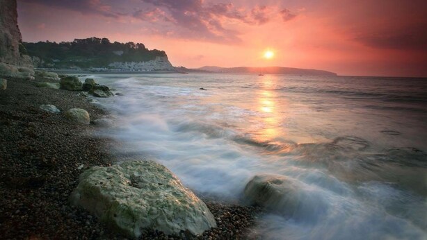 A beach with a sunset, calm water, and rocky shoreline. - Belmont House Beer - Adults Only (Seaton)