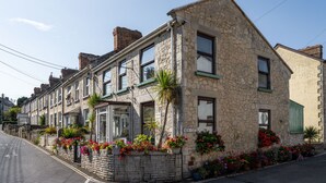 A stone building with multiple windows and a 'NEW CUT' sign, surrounded by colorful flower boxes. - Belmont House Beer - Adults Only (Seaton)