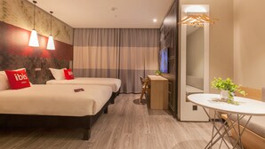 A hotel room with two beds, a desk, a TV, and a small table with a plant. - Ibis Wuhan Hubu Alley Hotel (Wuhan)