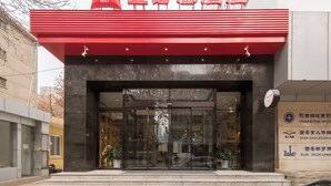 A hotel entrance with a red awning and glass doors. - Ibis Xian Xingqing Palace Park Hotel (Xi'an)