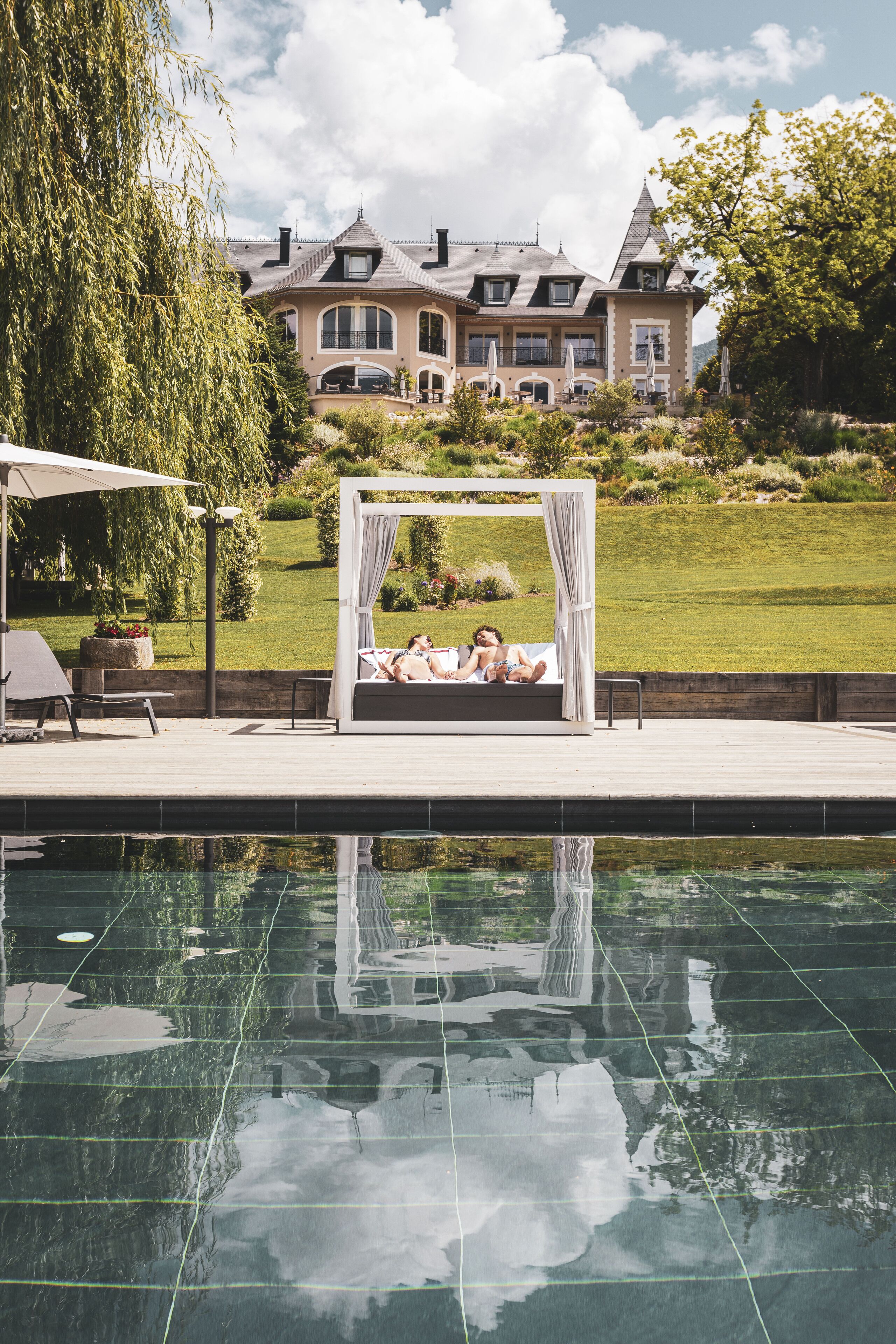 Una piscina cubierta, una piscina al aire libre, tumbonas