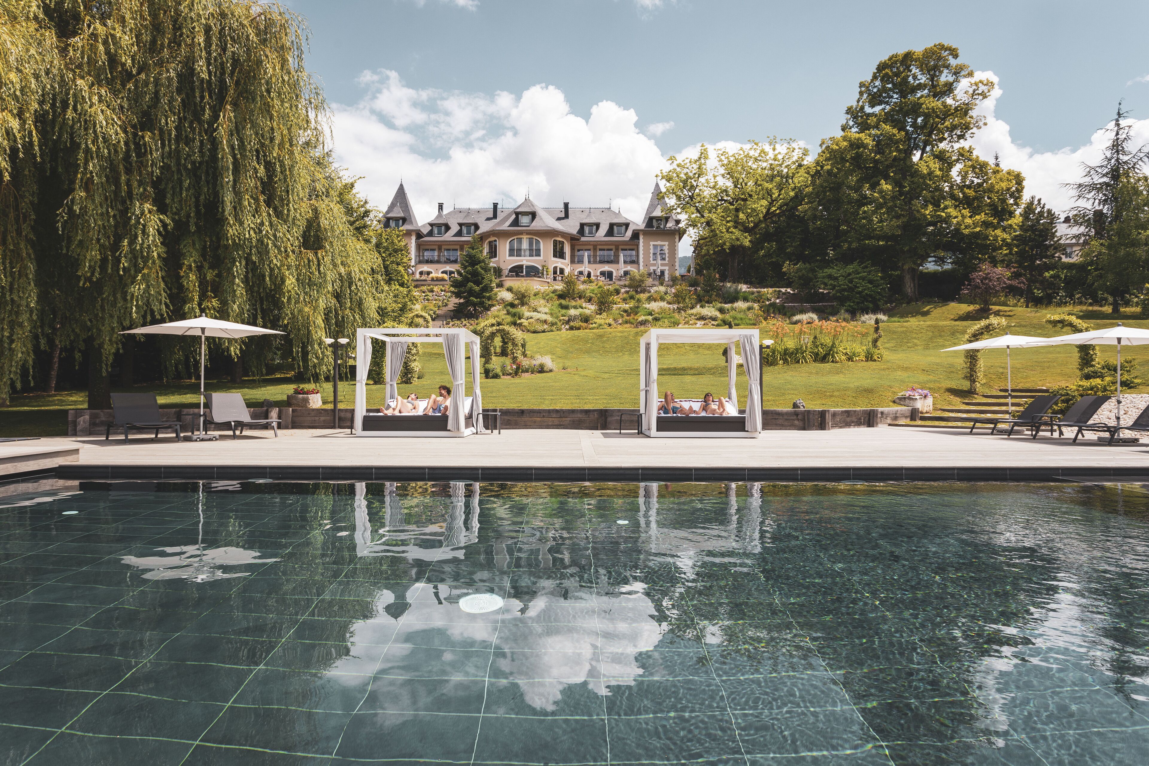 Een binnenzwembad, een buitenzwembad en ligstoelen