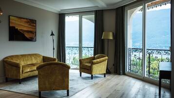 Suite junior, vistas al lago | Zona de estar | Una televisión de pantalla plana