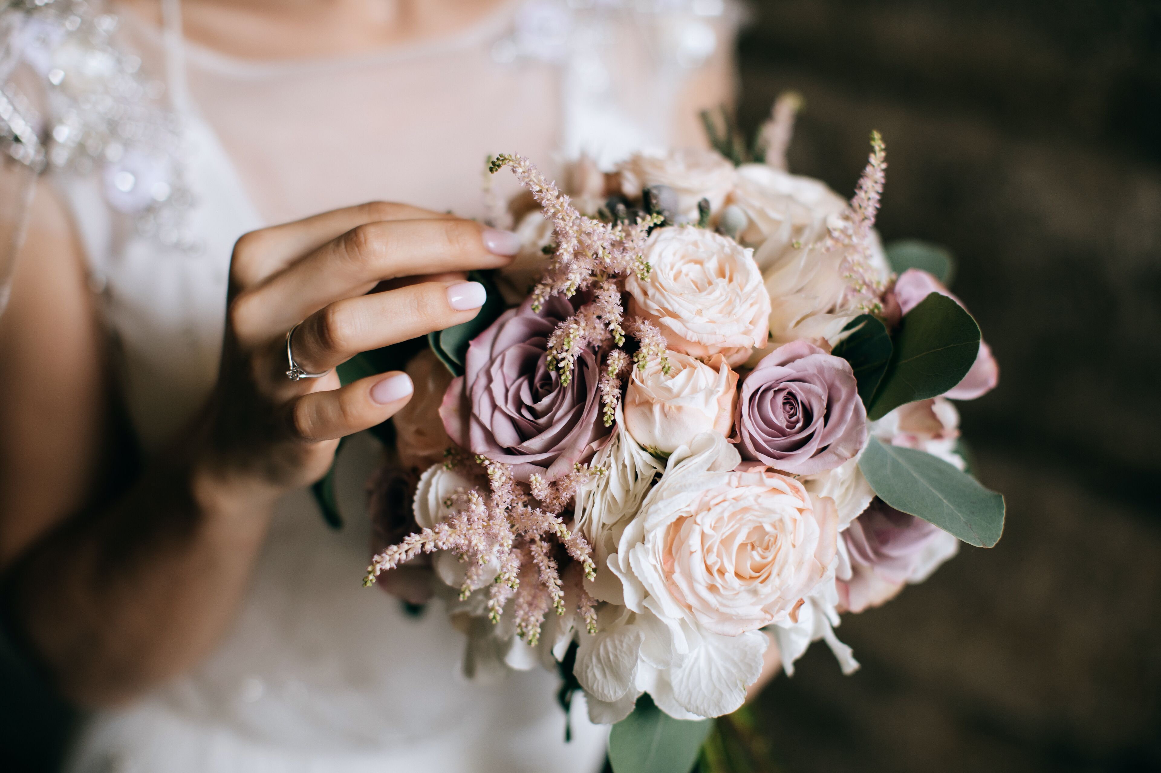 A close-up of a hand holding a bouquet of flowers.