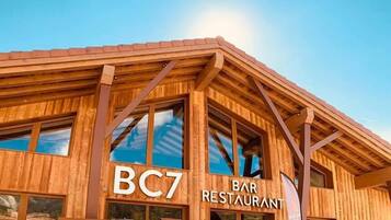 Un edificio de madera con ventanas grandes y un cartel que dice "BC7 BAR RESTAURANT".