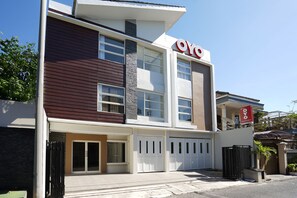 A modern two-story building with a prominent 'OYO' sign, large windows, and a gated entrance. - OYO 781 Erga Family Residence Syariah (Surabaya)
