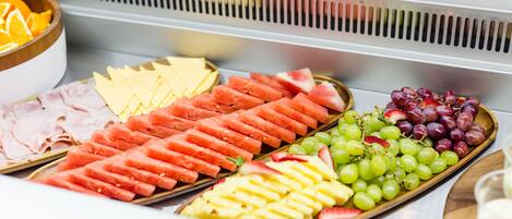 A buffet with various fruits and cheeses.