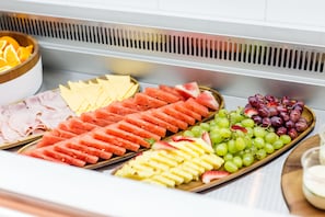 A buffet with various fruits and cheeses.