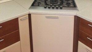 Una cocina con estufa a gas, campana extractora de acero inoxidable y armarios de madera.