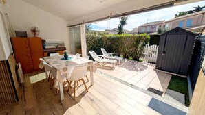 A patio area with a table and chairs, a wooden cabinet, and a small shed. - Holiday house for 4 people, 2 bedrooms, new conservatory, in a secured residence with pool LE... (PORTIRAGNES)