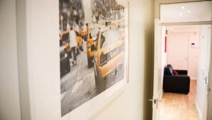 Um corredor com uma fotografia emoldurada de um táxi amarelo na parede.