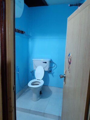 Un baño pequeño con inodoro, lavamanos y puerta.