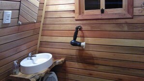 A wooden cabin bathroom with a sink, a window, and a heater. - Pousada Bolicho Guabiroba (Cambara do Sul)