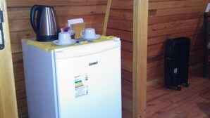 A small room with a white refrigerator, a coffee maker, and a cup on top. - Pousada Bolicho Guabiroba (Cambara do Sul)