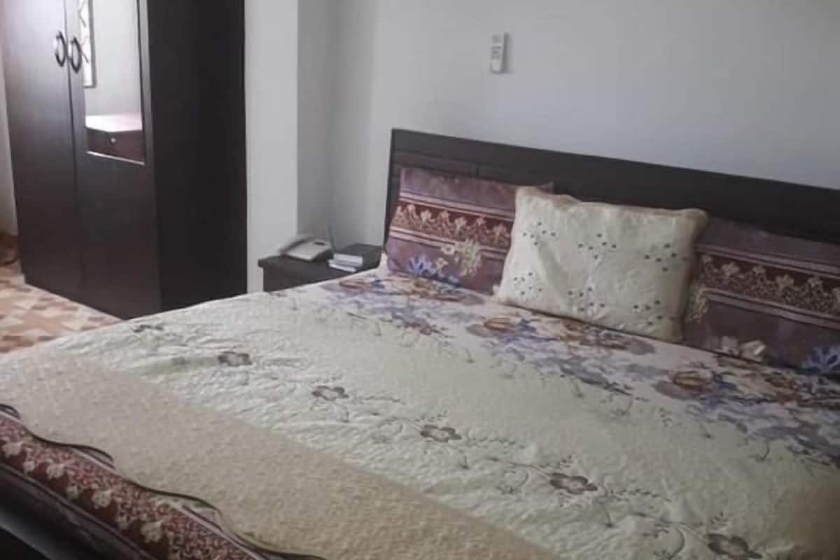 A bedroom with a bed, a wardrobe, and a nightstand.