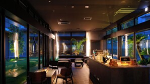 Ein moderner Innenraum mit Essbereich, Bar und großen Fenstern mit Blick hinaus.