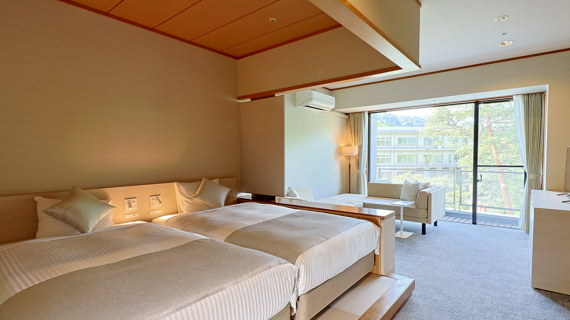 Une chambre d’hôtel avec deux lits, un bureau, une chaise et un balcon avec vue.