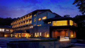 Ein mehrgeschossiges Hotel im modernen Stil, mit Innenhof und Parkplatz.
