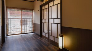 A traditional Japanese interior with sliding doors, a wooden floor, and a wall-mounted light fixture. - Shinseikan (Nishiwaga)