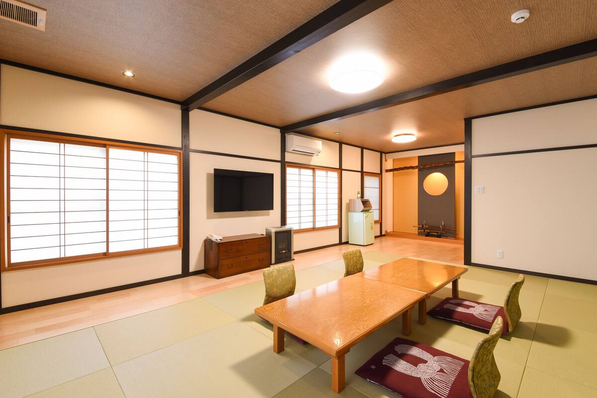 A traditional Japanese room with tatami flooring, a wooden table, and shoji screens.