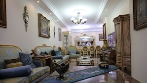 A luxurious living room with ornate furniture, a chandelier, and a large mirror. - Luxurious and Panoramic Nile view. (Cairo)