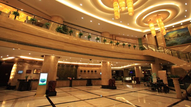 A spacious lobby with a high ceiling, multiple floors, and a central staircase.