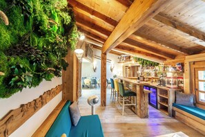 A rustic interior with a wooden ceiling, a bar area, and a seating area with a bench and a table. - CHALET DE LUXE in MERIBEL, 18 pers - swimming pool - services included (Les Allues)