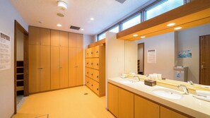 Un baño moderno con armarios de madera, dos lavamanos y un espejo grande.