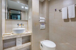 Ein Badezimmer mit Marmorwaschbecken, Toilette und Duschbereich.