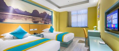 A hotel room with two beds, a desk, a TV, and a painting of a mountain landscape.