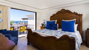 A hotel room with a large bed, a balcony with a view, a sofa, and a wooden nightstand. - Stunning 3 BR Villa at Hacienda Encantada in Cabo!  New Years Week!
Sleeps 10! (Cabo San Lucas)