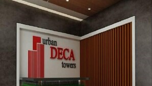 A reception desk with a sign for 'urban DECA towers'.