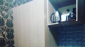 A compact kitchen with a built-in water dispenser, a sink, and a small countertop.