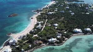 An aerial view of North Star, featuring a coastal layout with houses, clear turquoise waters, and a sandy beach. - North Star - A completely secluded home - the quintessential beach bungalow (Elbow Cay)