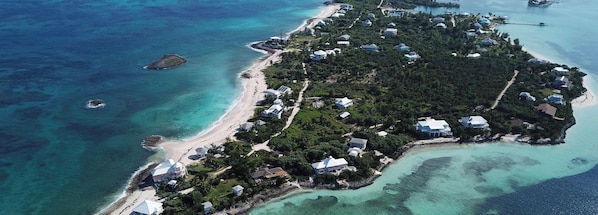 Vista aérea do North Star, com disposição costeira que inclui casas, águas turquesa cristalinas e uma praia arenosa.