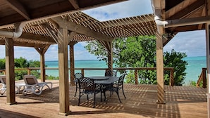 A wooden deck with a pergola, outdoor seating, and a view of the ocean. - North Star - A completely secluded home - the quintessential beach bungalow (Elbow Cay)