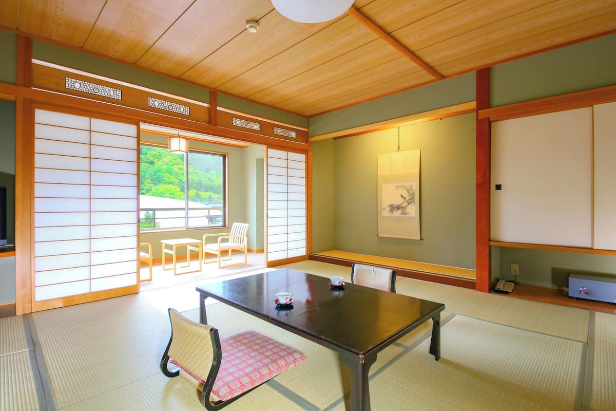 Um quarto japonês tradicional com tatames, uma mesa baixa e painéis shoji.
