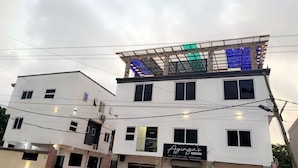 Un edificio de varios pisos con un cartel que dice 'Aying's' en la planta baja.