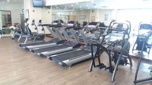 Ett gym med flera löpband, motionscyklar och annan träningsutrustning.