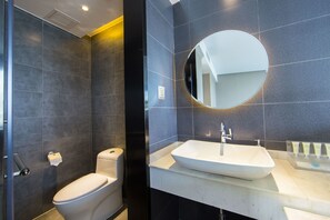 A modern bathroom with a toilet, sink, and mirror. - Yunman Hotel Kunming Donghua (Kunming)