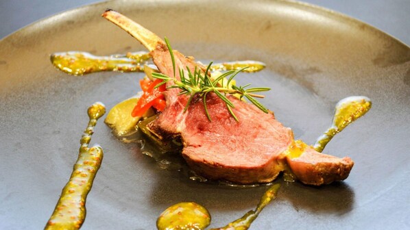 A plated dish with a lamb chop, vegetables, and a sprig of rosemary. - Rikuzentakata Capitalhotel1000 (Rikuzentakata)