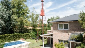 A residential property with a windmill, a swimming pool, and a brick house.