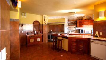 Una cocina con armarios de madera, una isla central, un microondas y un lavavajillas.