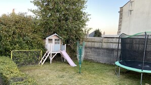 A backyard with a playhouse, a slide, a trampoline, and a soccer goal. - Ivy Cottage Serviced Accommodation (Aberdeen)