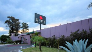 Een motelteken met een appel logo, omgeven door een grasveld en een paars gebouw.