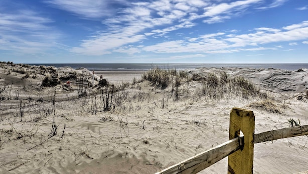 A beach with sand dunes and a wooden fence. - Coastal Condo w/ Pool, 1 Block to Wildwood Beach! (Wildwood)