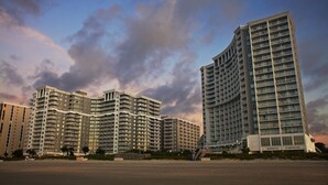 Ein mehrstöckiges Hotel mit bogenförmiger Fassade in Strandnähe.
