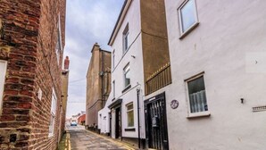 Une rue étroite bordée de bâtiments traditionnels en briques et aux façades blanches.